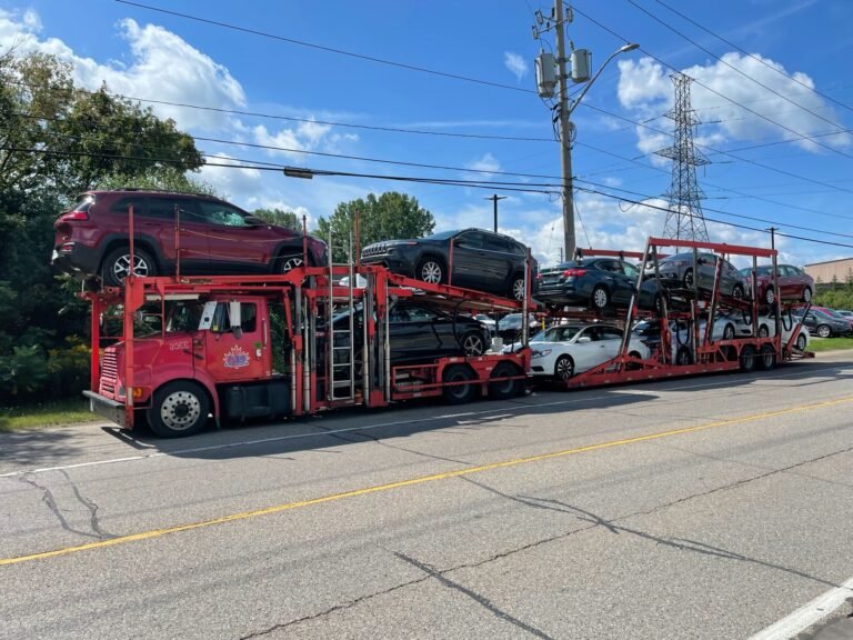 A.B. car transport between USA and Canada using red truck