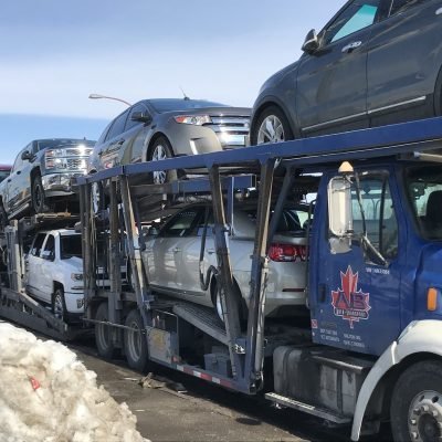 A.B. car transport between USA and Canada using blue truck
